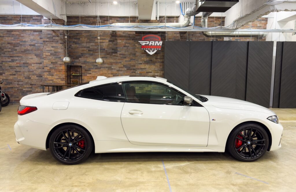 White BMW M440i coupe, side view